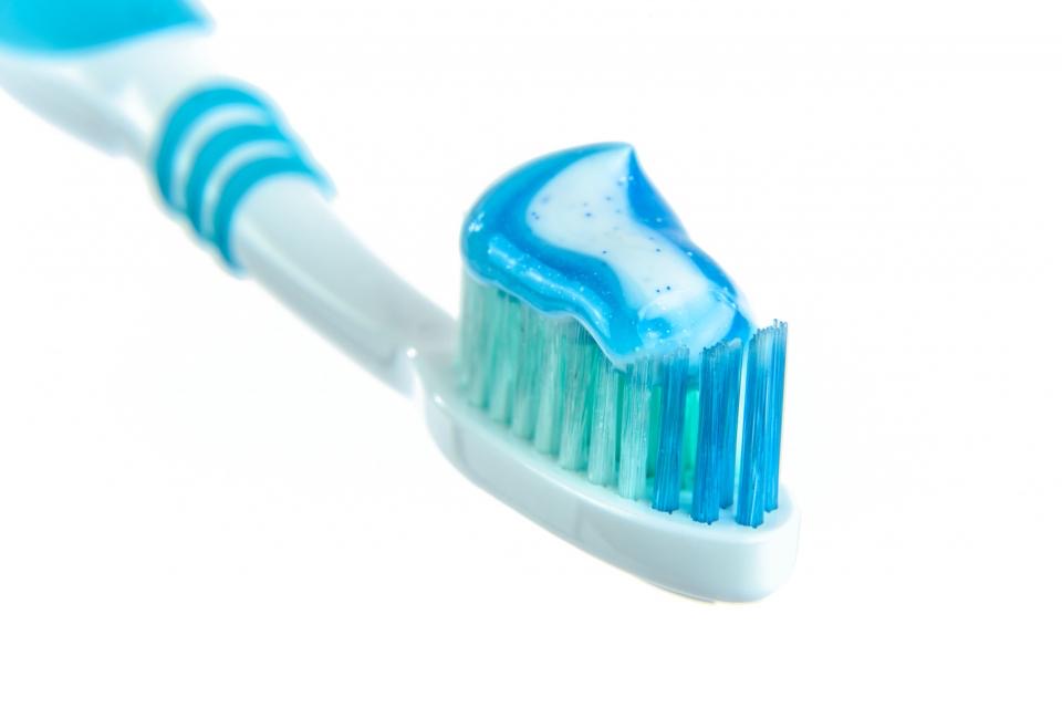 A toothbrush and toothpaste on a plain background